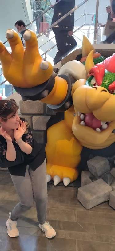 Danielle playfully recoiling as a giant Bowser statue reaches for her
